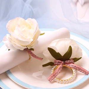 Elegant white floral napkin ring with pearl accents and pink ribbon for table decor