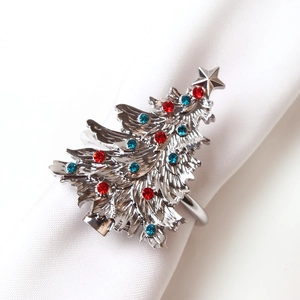 Silver Christmas tree napkin ring with red and blue rhinestones on white napkin