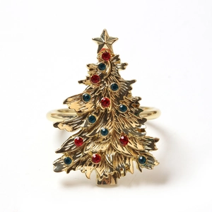 Close-up of golden Christmas tree napkin ring with colorful rhinestones and star detail