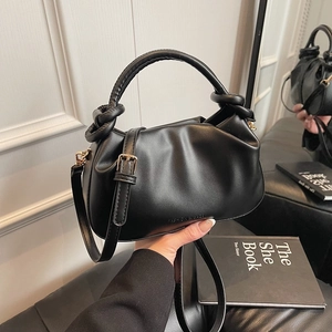 Fashionable black pleated bucket bag with twisted handle and detachable crossbody strap