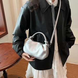 Silver pleated cloud bucket bag with metallic finish for handheld and crossbody styling