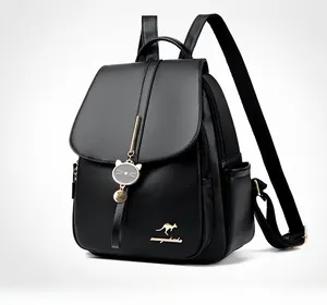 Close-up of black lychee texture leather backpack with kangaroo logo and gold cat pendant