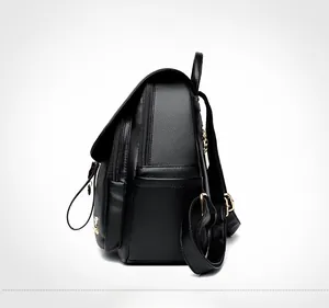 Detail view of black lychee grain leather backpack with golden zippers and side pocket