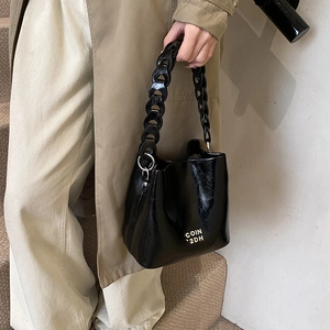 Sac seau noir brillant en cuir ciré avec bandoulière en chaîne acrylique épaisse