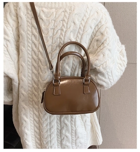 Brown mini bowling shoulder bag styled with a cream sweater for a cozy autumn look