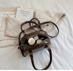 Detailed interior of a vintage brown leather handbag showing space for cosmetics