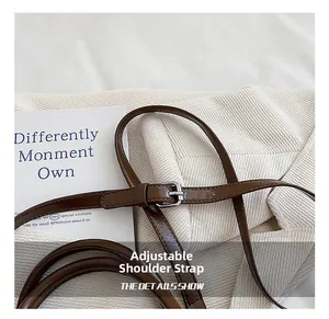 Close-up of the adjustable brown leather shoulder strap with a silver metal buckle
