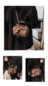 Détail d'un sac à main en cuir marron grainé avec fermoir doré et pendentif coeur