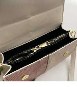 Detail of contrast color crossbody bag with weave texture and golden hardware