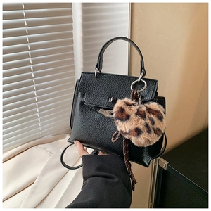 Détail du sac Kelly en cuir grainé noir avec fermoir argenté et breloque cœur léopard