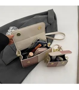 Detail of color-block flap bags in pink and khaki on a grey suit with internal space view