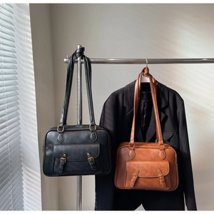 Vista detallada de bolsos vintage negros y caramelo con hebillas de metal retro