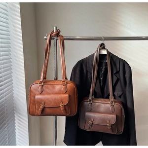 Detalle de bolsos mensajeros vintage con hebillas y solapas magnéticas en una percha