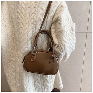 Detail of vintage brown glossy square bag with silver hardware and shoulder strap