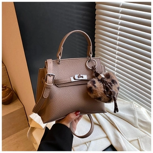 Détail du sac Kelly en cuir grainé avec fermoir argenté et bijou de sac en fourrure