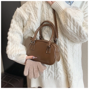 Detail of caramel brown mini Boston bag with glossy PU leather and detachable strap
