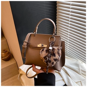 Détail du sac Kelly en cuir marron grainé avec un pendentif coeur léopard