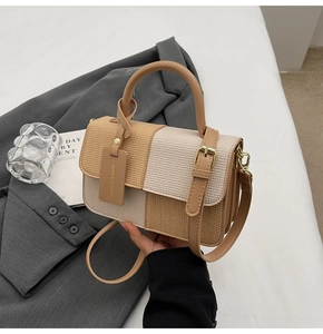 Detail der Handtasche mit Farblock-Design, gewebter Textur und goldenen Beschlägen