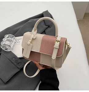 Detailansicht der farbblockierten Mini-Tasche mit Metallverschluss und gewebter Lederstruktur