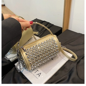 Close-up of gold cylinder barrel bag with shimmering rhinestones and chain strap