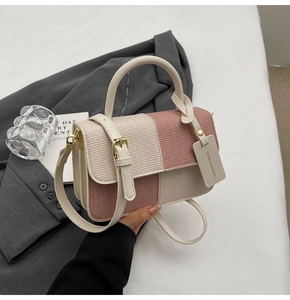 Detail der rosa und cremefarbenen Handtasche mit Goldbeschlägen und Anhänger
