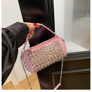 Detailed view of a pink cylinder handbag with silver rhinestones and chain strap