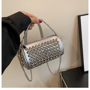 Detail of silver cylindrical rhinestone bag showing sparkling crystals and chain strap