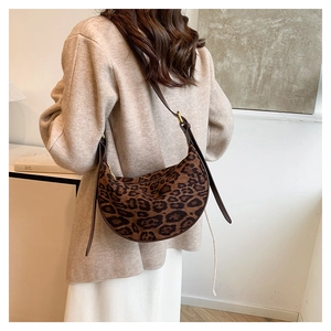 Model wearing a vintage leopard print crossbody bag with dark brown adjustable strap