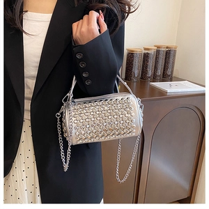 Silver cylinder handbag with sparkling rhinestones and metal chain handle close-up