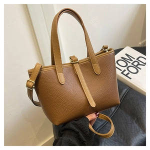 Detail of soft brown lychee grain leather tote bag with gold metal hardware and strap