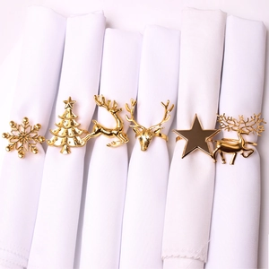 Detailed view of golden Christmas napkin rings with snowflake and reindeer motifs