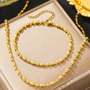 Parure de bijoux en acier titane doré avec collier et bracelet à perles ovales et rondes