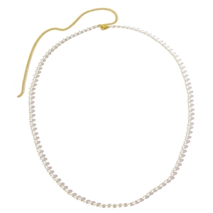 Minimalist pearl body chain with gold snake link belt and white round pearls on white surface