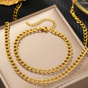 Set collana e bracciale a catena barbazzale dorata esposto su un portagioie di seta fine