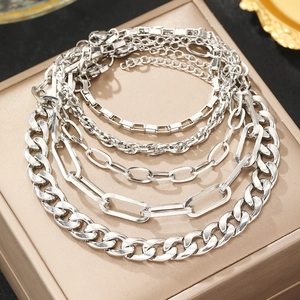 Five-piece silver link chain bracelet set featuring Cuban and paperclip styles on a jewelry box