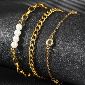 Ensemble de bracelets dorés superposés avec perles blanches et zircons scintillants