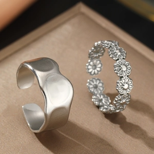 Set of silver stainless steel rings featuring wavy texture and daisy floral patterns