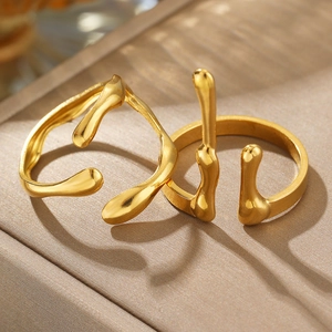 Detailed view of two irregular liquid gold rings with organic fluid metal design textures