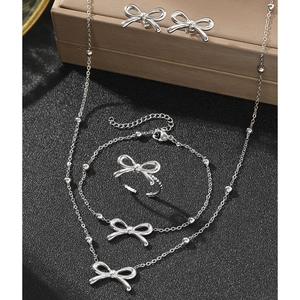 Detailed view of 4-piece silver bowknot jewelry set with necklace bracelet ring and earrings