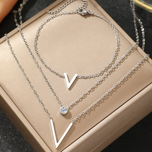 Vue macro de la parure de bijoux argentés avec pendentif en V sur boîte cadeau