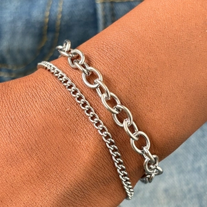 Close-up of double-layered stainless steel chain bracelet on blue denim background