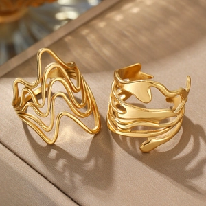 Detailed shot of irregular gold lava rings with wavy design and polished metal texture