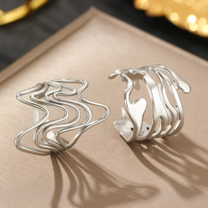 Minimalist silver lava irregular wave design earrings on a premium matte display stand