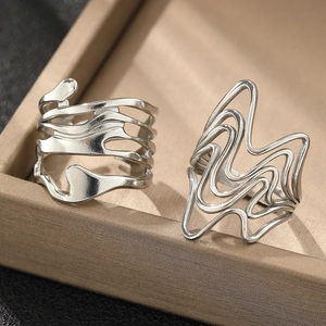 Close-up of silver lava-style rings with irregular hollow lines on jewelry tray