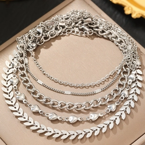 Dettaglio del set di cavigliere boho in argento con ciondoli a cuore e foglia