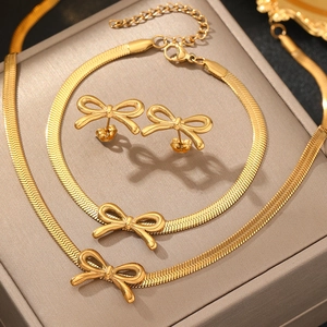 Elegant gold bow jewelry set with snake chain necklace, bracelet and stud earrings