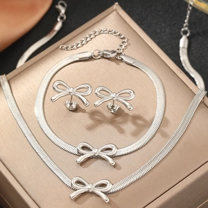 Detail shot of bow-knot necklace and earrings set displayed on a luxury gold jewelry box