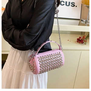 Detailed view of pink cylinder bag featuring silver rhinestones and chain strap on model