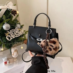 Sac à main style Kelly en cuir grainé noir avec pompon léopard et décor festif