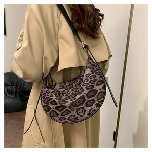 Detail of vintage leopard print crescent bag on a model wearing a khaki trench coat